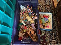 Blue tub filled with various Barbie and other dolls in different poses, some nude, some clothed