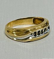 Angled profile of ring showing two-tone band and stone channel