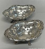 Two vintage Birks sterling silver mini footed bowls showing the interior pierced floral pattern and decorative edges.