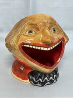 Front angle showing ceramic clown candle holder with open mouth cavity and painted facial features.