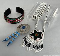 Photo showing the whole lot: the Native American style beaded necklace with pendant and a Maison Scotch beaded cuff bracelet both placed together.