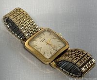 Full view of vintage Benrus wrist watch showing gold electroplated case and expandable band on a neutral background.