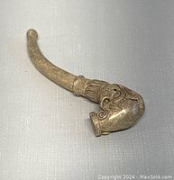 Curved silver plated pipe showing dragon design on bowl