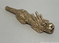 Photo showing side angle of silver plated dragon pipe with intricate details front and top.