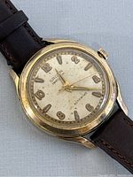 Close-up of watch dial showing brand name 'Gruen Precision' and 'Autowind' with cream dial and dark gold-tone numerals and hands.