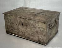 Full side view showing floral hand engraved patterns and side handle with floral detail on the vintage silver plated jewelry box.