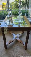 Front view of the wood and glass side table with crystal lamps placed on top showing overall structure and design