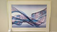 Overall view of the signed abstract artwork showing flowing ribbons in blue, purple and pink tones, framed with a cream mat and gold frame.