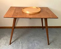 Front view of Paul McCobb table with round wooden tray on top