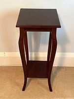 Front view of antique style side table with curved legs and square top.