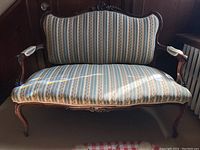 Front view of full settee showing carved crest, seat and legs