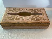 Top view of the rectangular pink wooden tissue box decorated with gold gilt scrollwork and an oval tissue opening.
