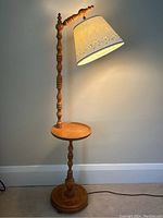 Full view of the vintage wooden floor lamp with integrated small round table and decorative floral paper lampshade, lit and unlit.