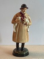 Full frontal photo of Royal Doulton Lambing Time figurine depicting an elderly man holding two lambs.