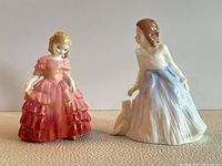 Pair of Royal Doulton figurines, Rose and Andrea, front view on neutral surface.