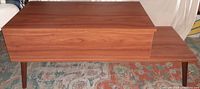Wooden coffee table, rectangular, closed lift top, tapered legs on a patterned rug