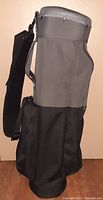 Side view of the lightweight golf cart bag in black and gray, showing adjustable shoulder strap and fabric construction.