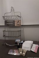 Full view of shower caddy with attached label 'Rust Resistant Shower Caddy' and self care products arranged underneath on table.