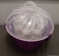 Front view of cupcake carrier showing clear dome lid and purple base