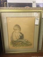 Front view of framed charcoal drawing showing boy holding a dog, double matted, under glass in decorative gold frame.