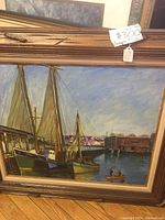 Front view of the framed oil painting showing sail ships docked at the marina under a blue sky, signed by Joseph Troll.