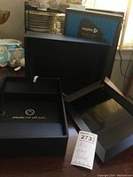 Opened box showing black digital photo frame and packaging with Nixplay branded box visible in background.