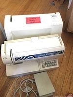 Front view of sewing machine and matching hard case on hardwood floor