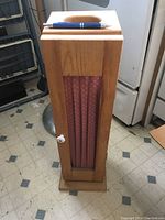 Front view of wooden cabinet with fabric panel and white knob