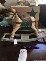 Wooden rocking horse on a table showing painted painted details and tags