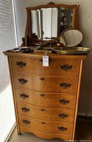 Front view of the birdseye maple tall boy dresser with five drawers and attached mirror, showing brass handles and keyholes.