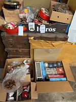 Overview of boxes and tins filled with assorted Christmas items on wooden trunk.