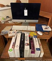 iMac with keyboard, mouse and software boxes on table
