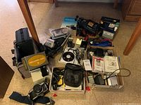 Overhead view of cameras, boxes, bags, accessories spread on floor