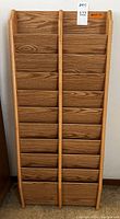 Front view of oak wooden wall rack showing vertical divided sections with horizontal slots for storing 8.5 x 11 items.