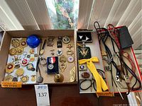 Overview of all pins displayed in cardboard box on left and bolo ties and accessories on right
