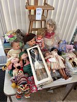 Front view of assorted dolls and highchair on table