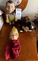 Overall group shot of Pinocchio doll, Figaro figurine, and Dopey puppet on wooden surface