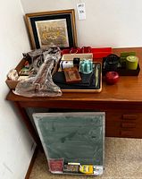 Image showing overall vintage office items arranged on a wooden desk, including a framed etching, desk sets, and various boxed office supplies.