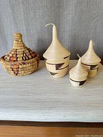 Photo of three nesting woven baskets with lids in natural and brown geometric designs.