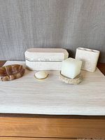 Overall view of marble decorative items including the rectangular box with shell inlay, soap dish, shell piece, candle with stand, and holder
