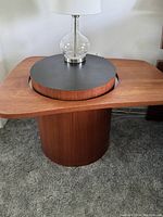 Front corner view with lamp illustrating rectangular teak top and floating black round tray.