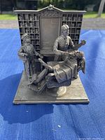 Full front view of the pewter sculpture depicting a barber, customer in chair, and assistant with detailed backdrop.
