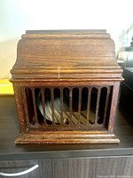 Closed wooden cabinet of Edison Model 30 phonograph showing front grille and wood finish.