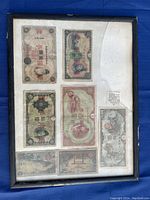 Framed display of seven Japanese bank notes of varying denominations and colors in circulated condition.