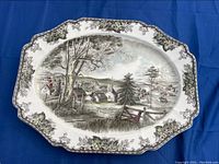 Top front view of the Johnson Brothers turkey platter showing the detailed Friendly Village pastoral village illustration and floral vine border.