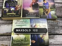 Five paperback books laid out on a wooden surface. Titles and authors visible on covers with period or rural themes, matching the set description.