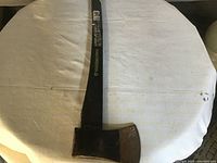 Full view of Yardwork axe with black composite handle and green accents, showing length and axe head condition.