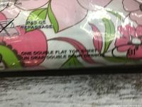 Close-up of fabric showing floral print and text 'One double flat top sheet'