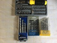 Photo showing socket set with yellow and black screwdriver handle and bits, and three packages of drill bits from Mastercraft and Craftsman.