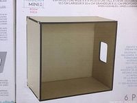 Single brown DIY Modern Mini cube with handle cutout, showing front, top and side panels, on product packaging.